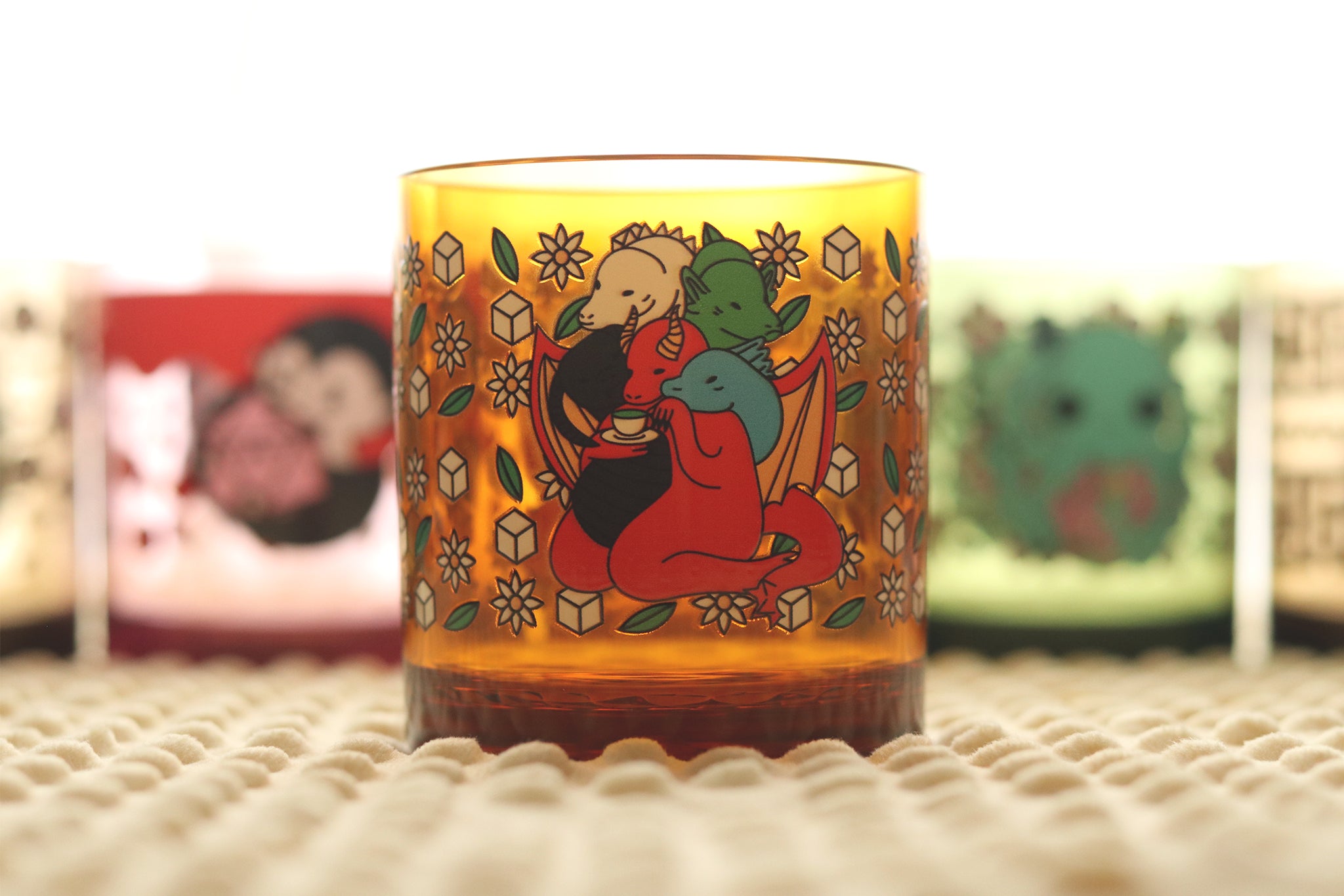 Golden-yellow drinking cup displaying a multi-headed dragon ,Tiamat, surrounded by decorative flowers, tea leaves, and sugar cubes.