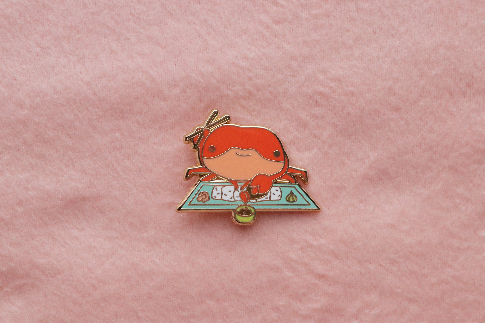 Enamel pin of cute Giant Crab eating california roll sushi with chopsticks