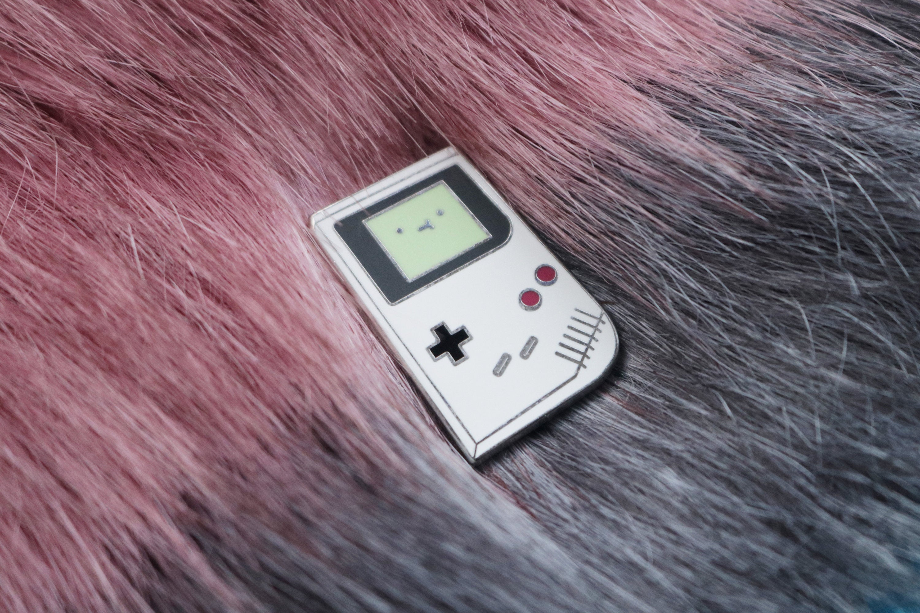 Game Boy Hard Enamel Pin on Maroon and Gray Fur Background
