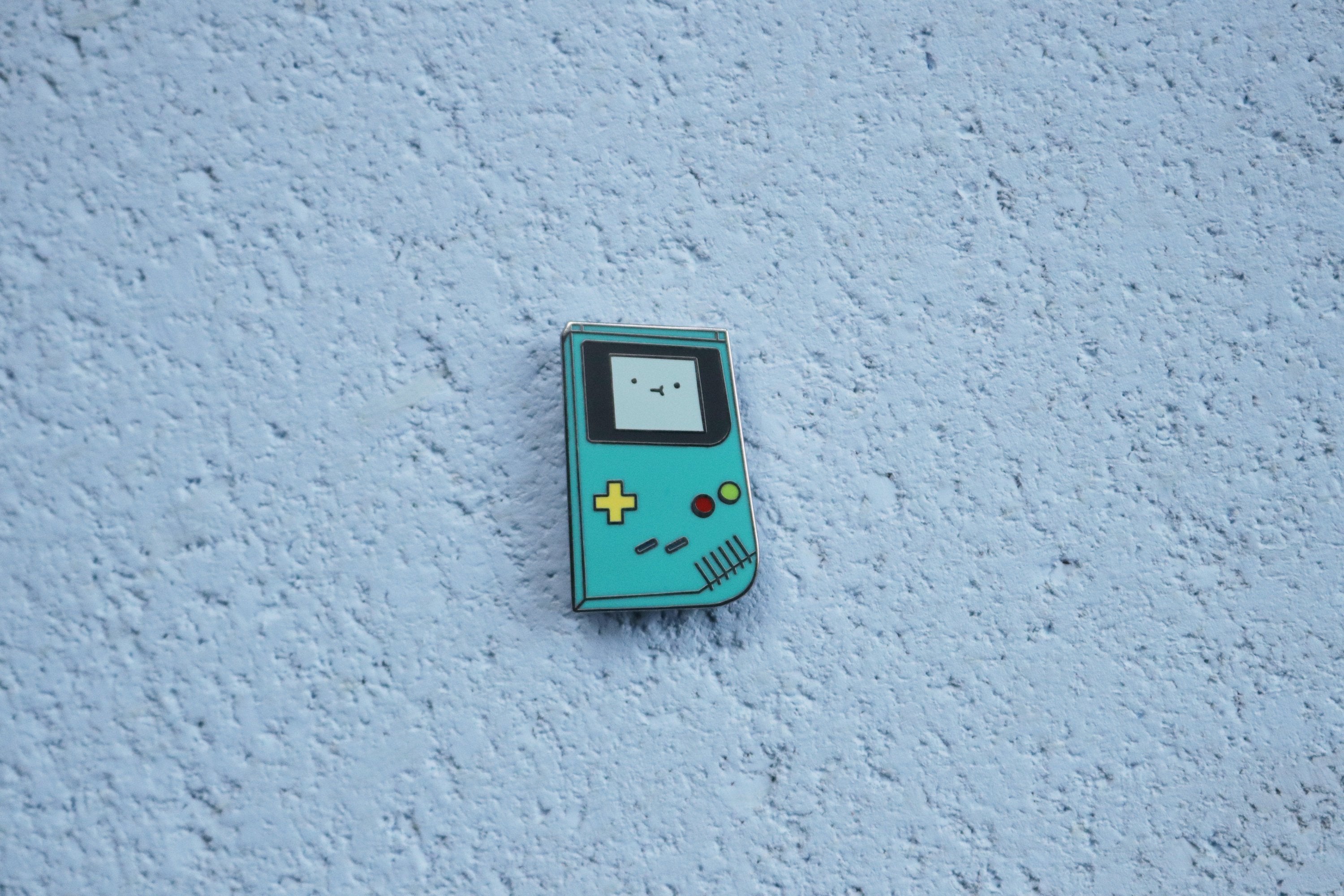 Teal Game Boy Color on Blue Cork Background